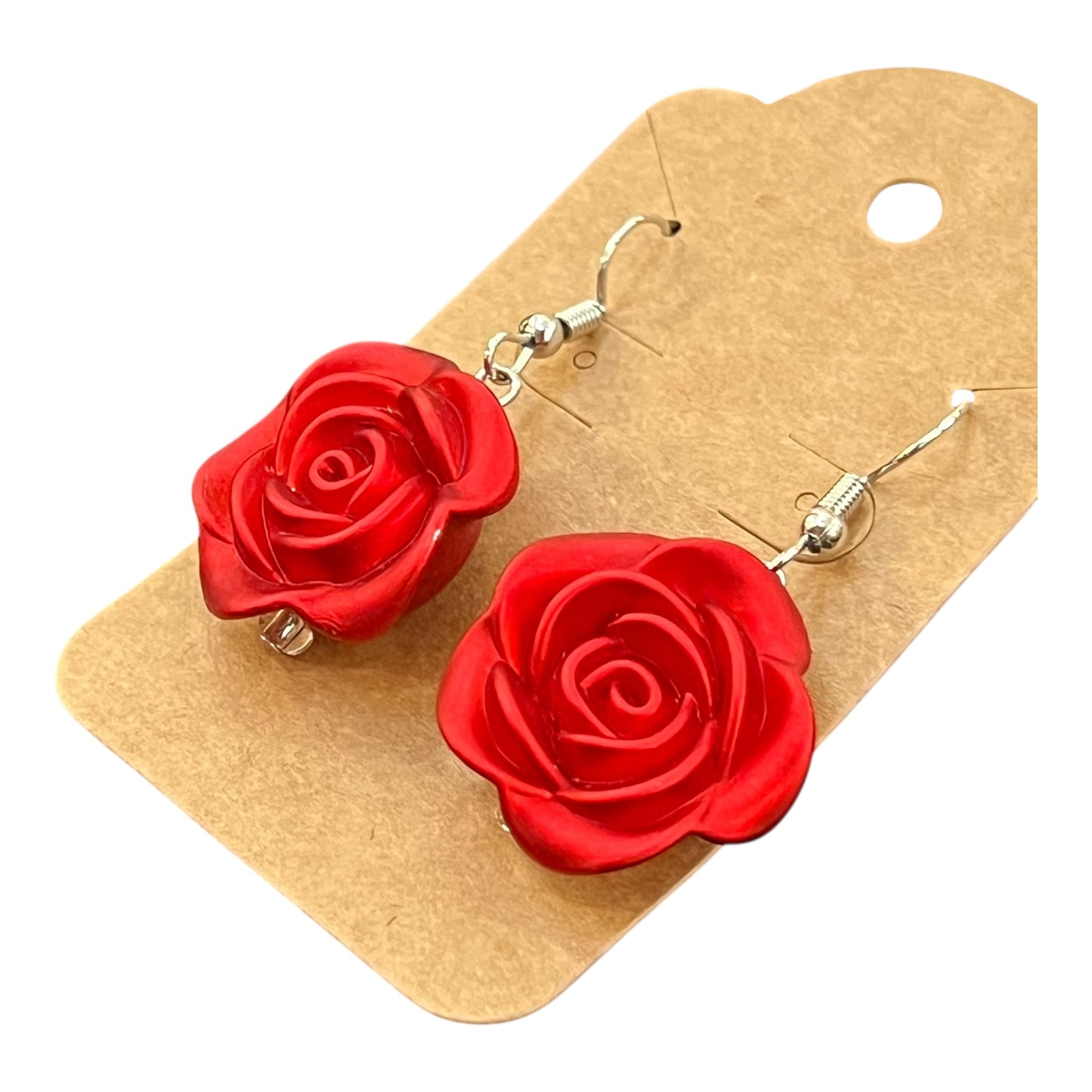 Red rose-shaped earrings on a JenDore brown cardboard backing