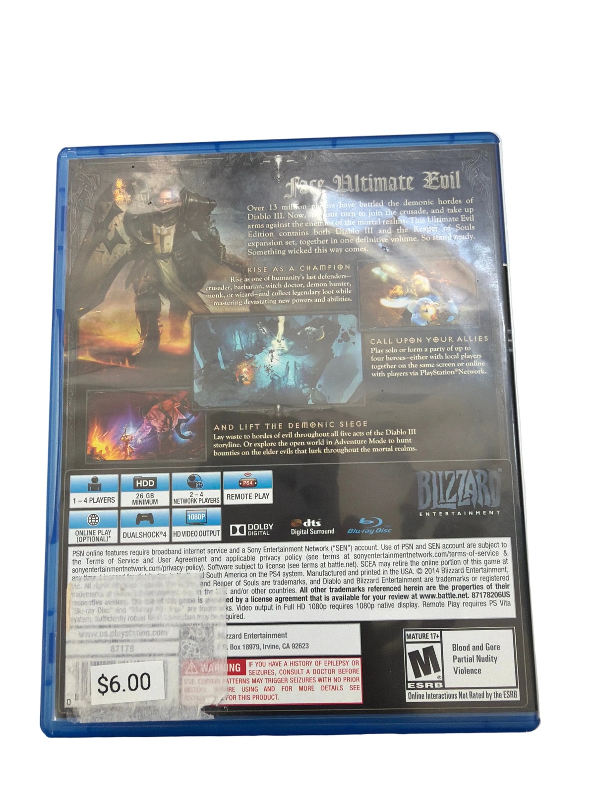 Back cover of a Blizzard Entertainment video game case, photographed on a white surface with a cutting mat visible around the edges. The cover shows artwork, feature icons, and a $6.