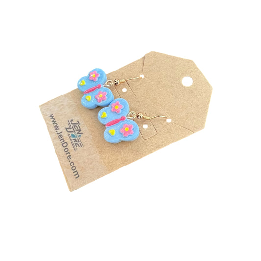 Butterfly-shaped earrings on a brown card with JenDore branding.