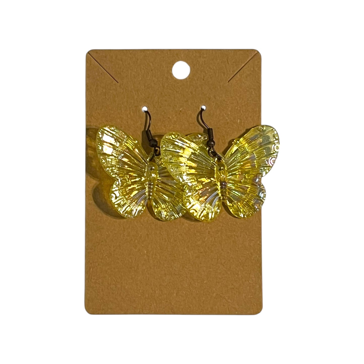 A pair of handmade yellow iridescent butterfly dangle earrings attached to a brown card with a hole at the top for display.
