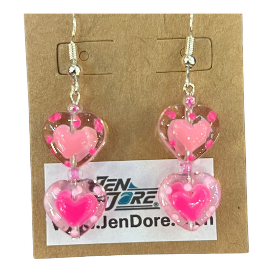 Pink heart-shaped earrings on a JenDore display card.