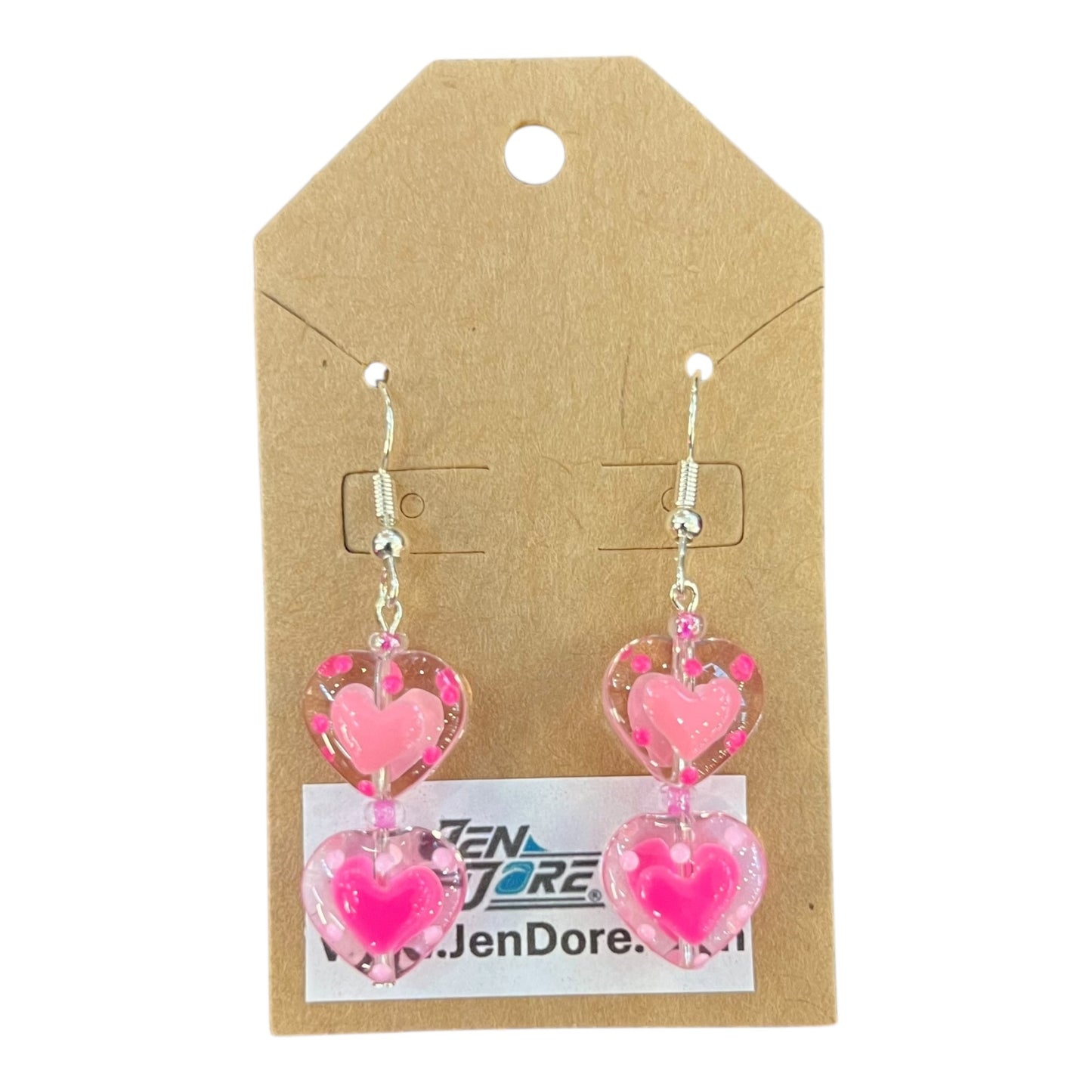 Heart-shaped pink earrings on a JenDore branded card.