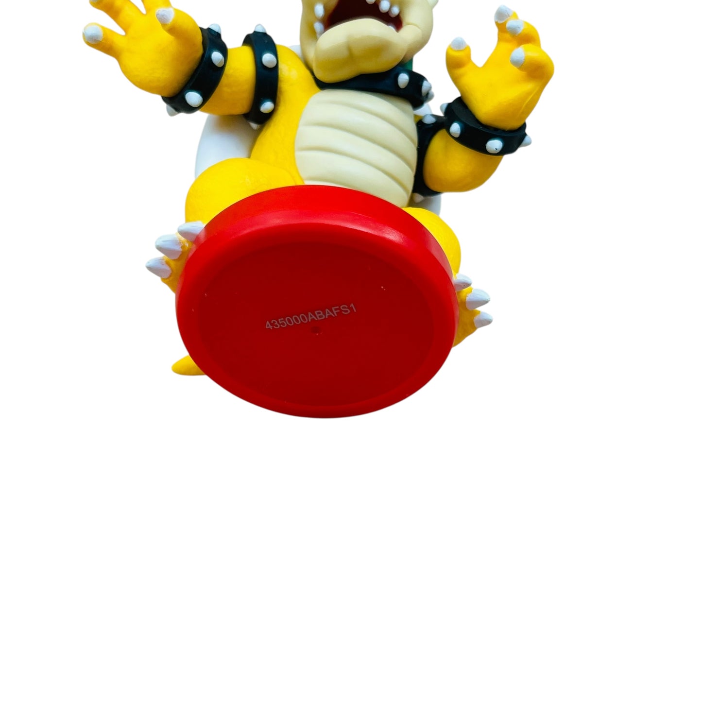 Toy figure with red base and yellow and white design on a white background