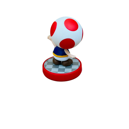 Figurine of a character standing on a mushroom with red spots on a white background