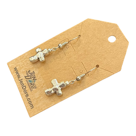 Silver cross-shaped earrings on a brown card with JenDore branding.