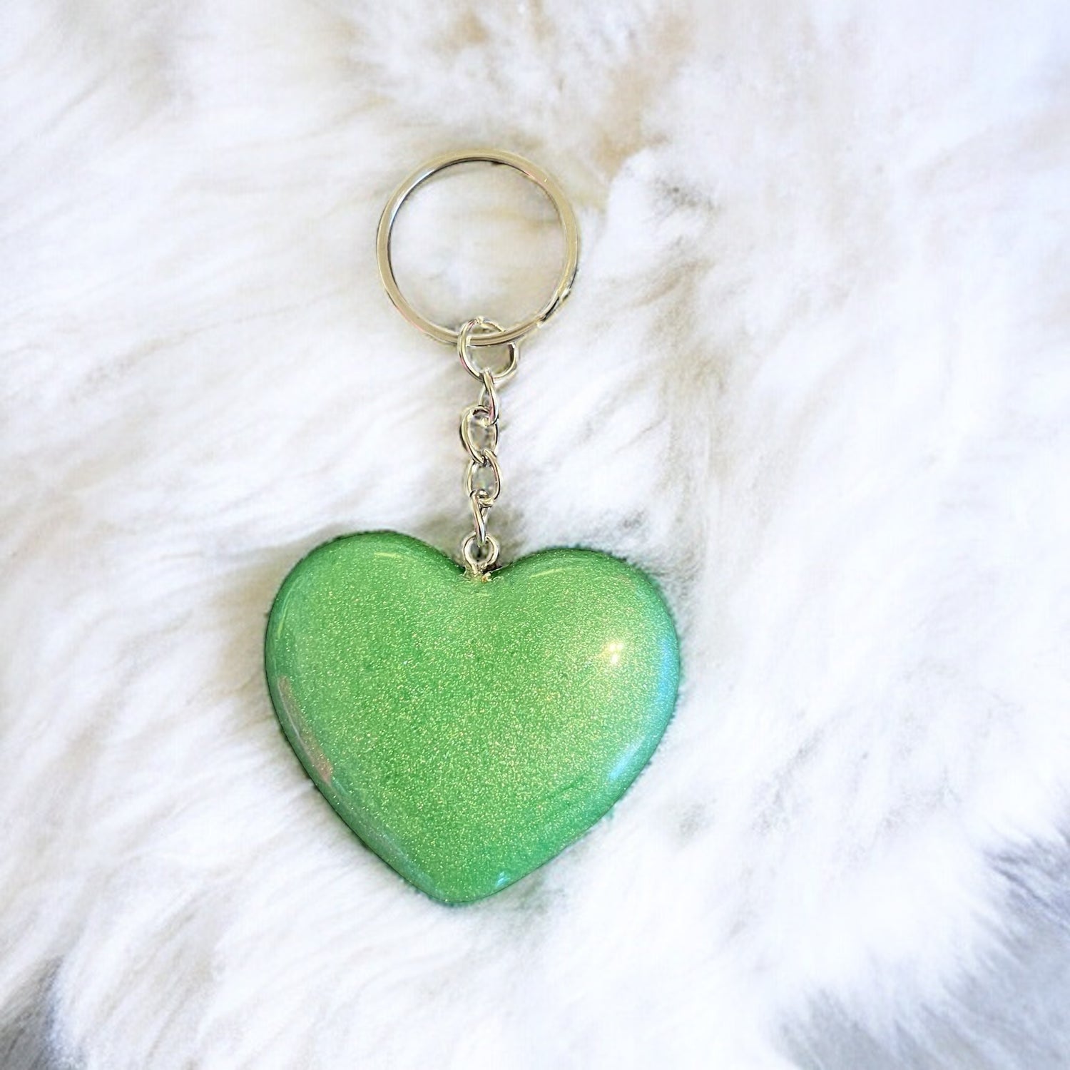 Shimmering Love Glam Hearts: JenDore Handmade Solid Green Glitter Sparkle Keychain with a grass bavkgroubd filled with small colored eggs