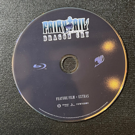 Blu-ray disc with 'Fairy Tail' branding on a textured surface