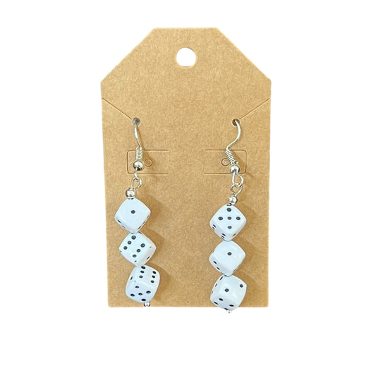 Pair of dice-shaped earrings on a cardboard backing