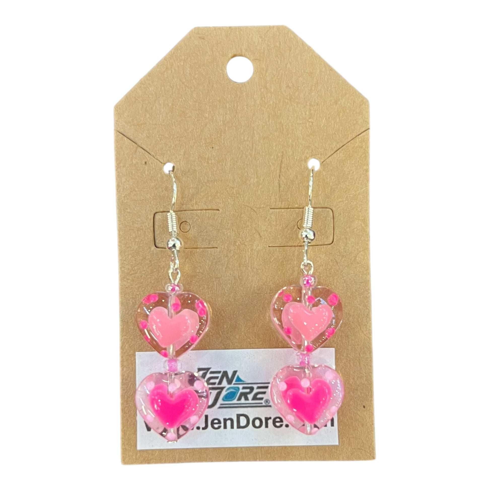 Heart-shaped pink earrings on a JenDore branded card.