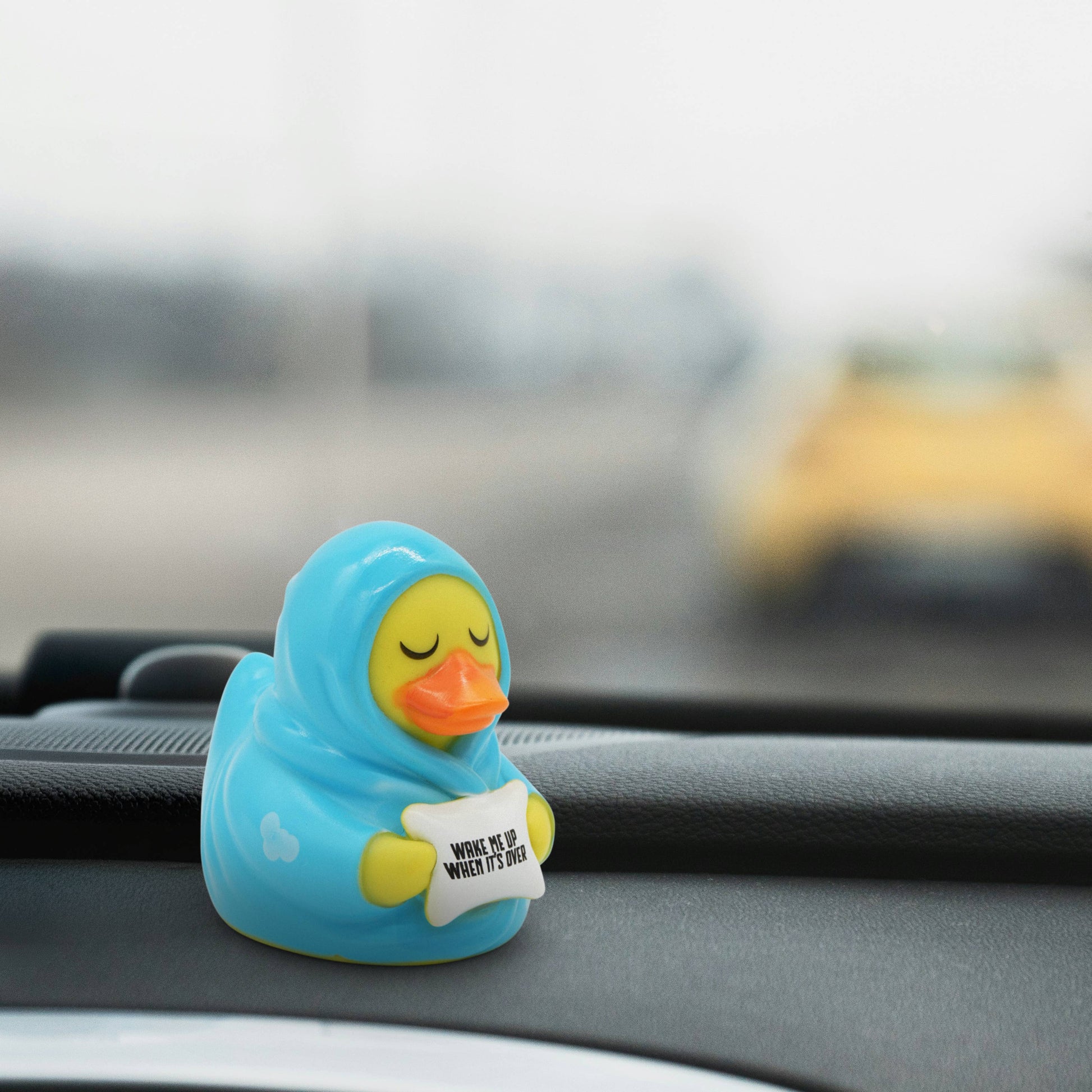 Rubber duck toy with a message on a car dashboard